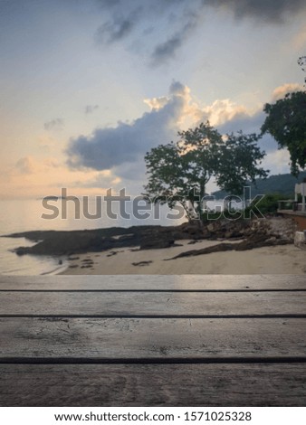 Picture of a wooden table with a blurry background in the sea The atmosphere in the morning and evening is still sunny. Is a natural concept and has space for characters. Copy space