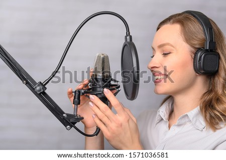 Girl with a studio microphone, Radio presenter, singer and blogger, voice acting for films. Radio ether, or blogger.