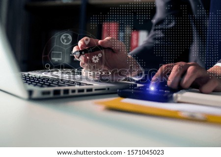 Businessman using on smartphone and laptop computer with Digital marketing media and virtual globe shape diagram.