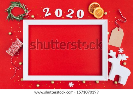 Festive christmas white frame made of christmas decorations and 2020 wooden numerals on red background with copy space. Flat lay, top view. Christmas, winter, New Year concept.