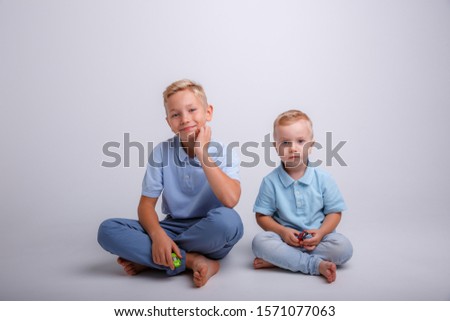 two brothers playing cars on a white background, two boys 