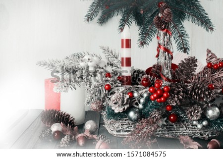 Christmas background with wicker basket, candle and star, fir tree, pine and spruce cones, acorns on shabby wooden old table, New Year winter holiday home natural material decor.