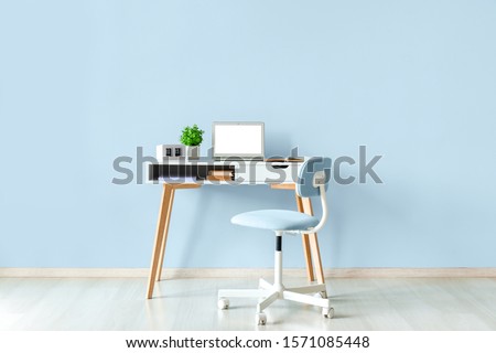 Modern stylish workplace with laptop near color wall