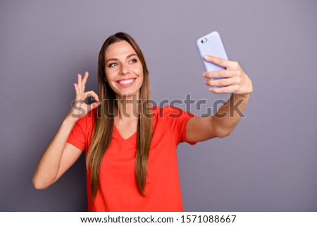 Portrait of charming cute cheerful girl have summer rest relax make selfie on her cell phone advertise trip show okay sign wear casual style outfit isolated over grey color background