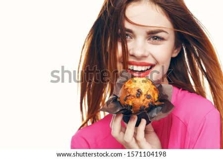 cheerful woman with a cupcake in hand