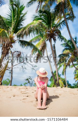 Young slim woman in straw hat lying on tropical beach.