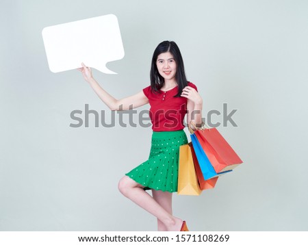 Studio portrait of young woman beautiful with colorful shopping bags and showing placard empty isolated on white background.