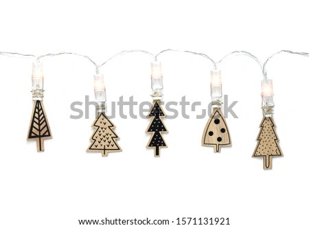 Decorative wooden and painted funny Christmas trees with led light arland isolated on white background, copy space. Happy New Year and Christmas greeting card concept. Scandinavian minimal flat lay