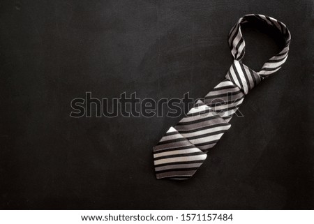 Father's day concept. Men's tie on black background top-down copy space