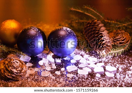 Beautiful Christmas background, blue balls, cones, ice, spruce branches. Everything is fabulously covered with snow. Concept, holiday symbol, Christmas, New year, fairy tale.