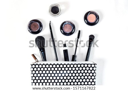 polka dot cosmetic bag and mascara brush eyeliner, monochrome flat lay makeup