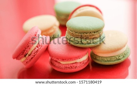 Pastry, bakery and branding concept - French macaroons on fruity red background, parisian chic cafe dessert, sweet food and cake macaron for luxury confectionery brand, holiday backdrop design
