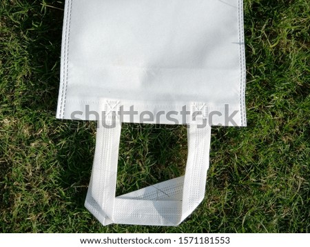 Isolated white Handle loop bag, ECO Bag, Non Woven bag on Grass Background