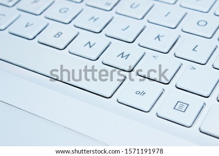 Blurred image of white laptop kayboard,  close up.  Laptop, technology concept. 