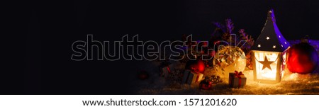 Christmas holidays card with gifts , balls and glowing lantern in snow over black background