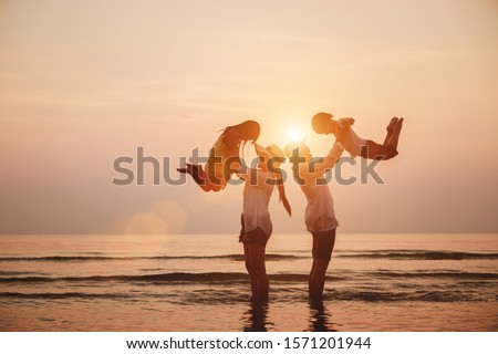 Family vacation holiday,  Silhouette of the happy family on the evening beach. Happy young family enjoys carrying children around the beach. 