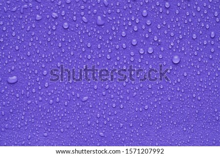 Water drops on lilac background, top view