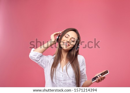 Woman listening wireless music with headphones from a smart phone