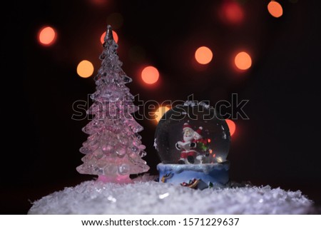Santa and his assistant a snowman, in a glass sphere, reads the list of gifts for children for a Christmas holiday