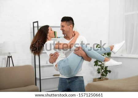 Happy young couple dancing together at home