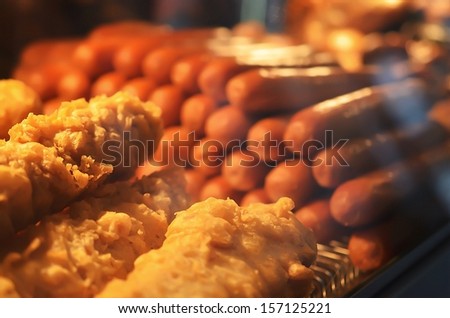 Battered fish and sausages in a fish and chip shop Royalty-Free Stock Photo #157125221