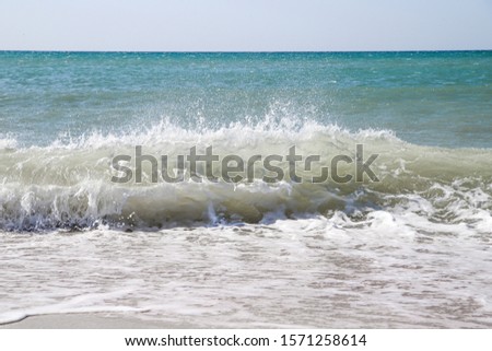 Blue sea wave and white foam on sand beach. Beautiful seascape background