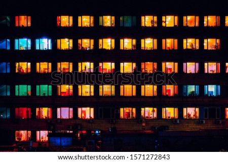 warm yellow red blue light inside windows at night Royalty-Free Stock Photo #1571272843