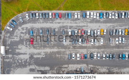Aerial view from above of the parking lot with cars in the business district of the city, wet asphalt