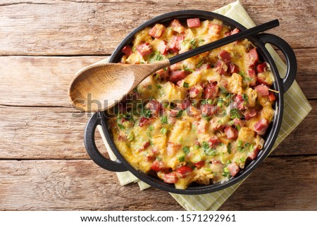 Tasty hot homemade strata with ham, onions, cheese and eggs close-up in a pan on the table. Horizontal top view from above
 Royalty-Free Stock Photo #1571292961