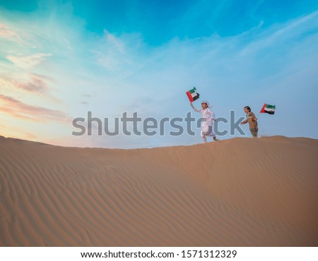 emirates kids are playing in desert Royalty-Free Stock Photo #1571312329