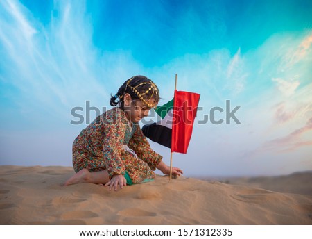 emirates kids are playing in desert Royalty-Free Stock Photo #1571312335