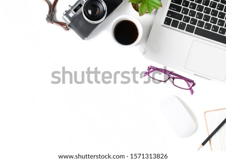 White office desk table with laptop computer and vintage camera, cup of coffee and glasses. Top view with copy space, flat lay.