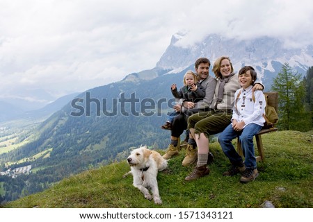 Young family sitting on bench in mountains of Austria