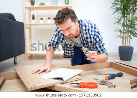 Man portrait and do it yourself furniture assembly Royalty-Free Stock Photo #1571358502