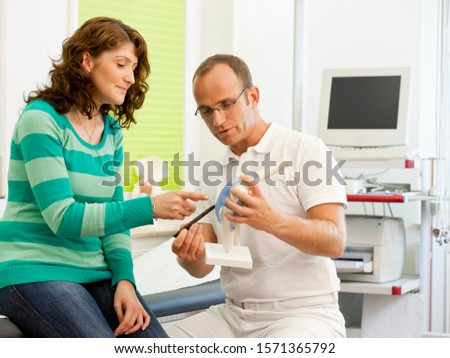 Doctor showing patient medical model in doctor's office