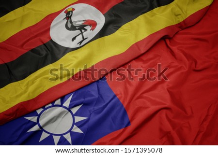 waving colorful flag of taiwan and national flag of uganda. macro