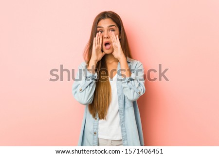 Young slim woman shouting excited to front.