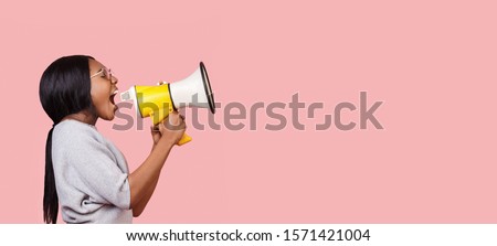 Making announcement. Black woman shouting in megaphone towards copy space over pink background, panorama Royalty-Free Stock Photo #1571421004