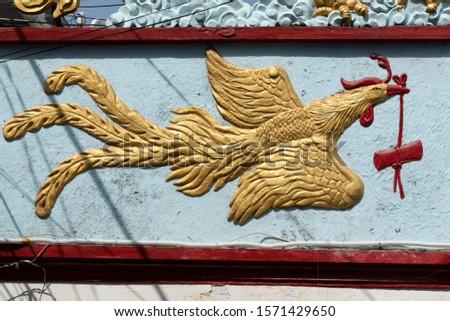 A Buddhist Golden Rooster symbol on the front of a temple in Vietnam