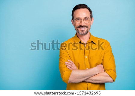 Portrait of charming mature man true boss feel content emotions wear yellow shirt isolated over blue color background Royalty-Free Stock Photo #1571432695