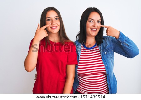 Young beautiful women wearing casual clothes standing over isolated white background Pointing with hand finger to face and nose, smiling cheerful. Beauty concept