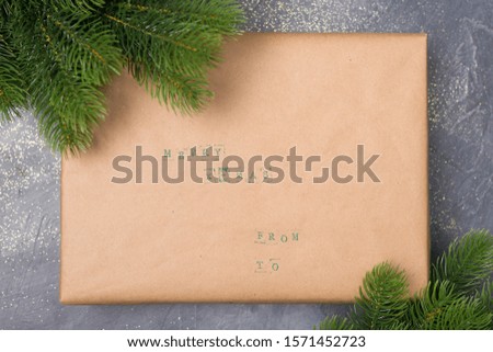 Christmas gift boxes decorated with craft paper, branch on dark background . Merry greeting card. Winter holiday theme. 