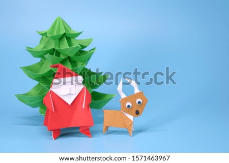 Origami paper art : Santa Claus, reindeer and Christmas tree for greeting season of Christmas and New year. Copy space