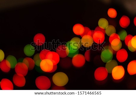unfocused multicolored lights on dark background with bokeh effect and copy space