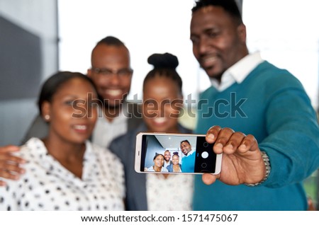 Four happy, attractive African American colleagues taking cellph