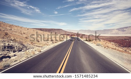 Desert road in Death Valley, color toning applied, USA.