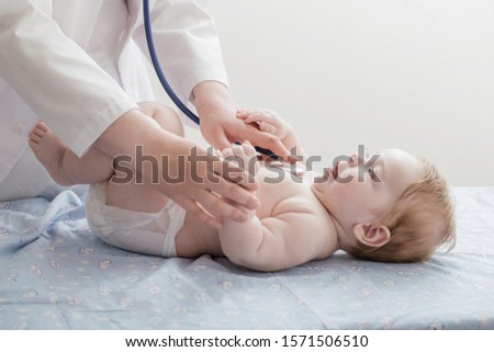 doctor listens to small child with  stethoscope