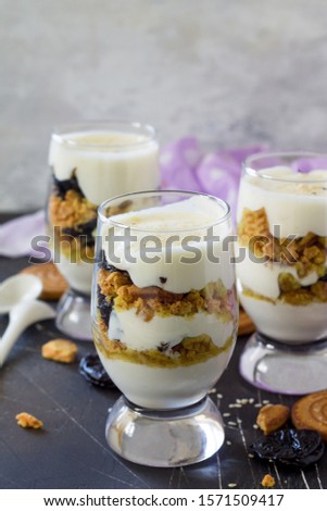 Dessert of crumbly cookies, orange and whipped cream on a dark stone countertop. Copy space.
