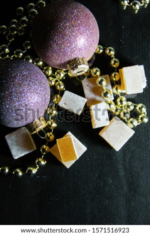 Apple pate de fruit (jelly, marmalade, fruit candy) with Christmas spices covered with icing sugar on a dark background, top view