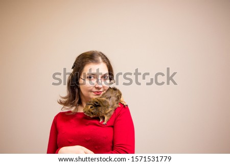  Young beautiful girl in glasses with her cute funny guinea pig